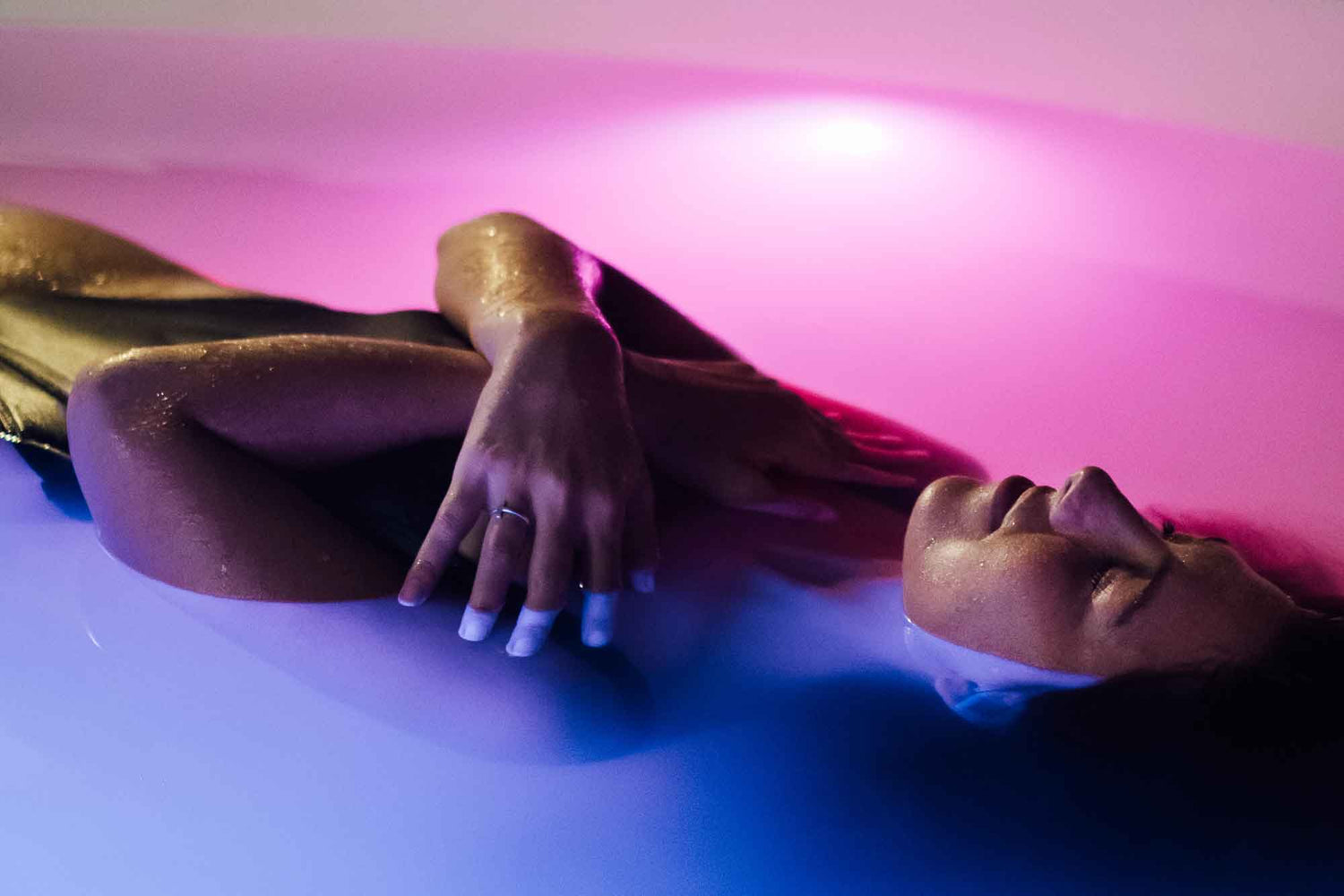 Float tank relaxation scene showing a person floating in a sensory deprivation tank